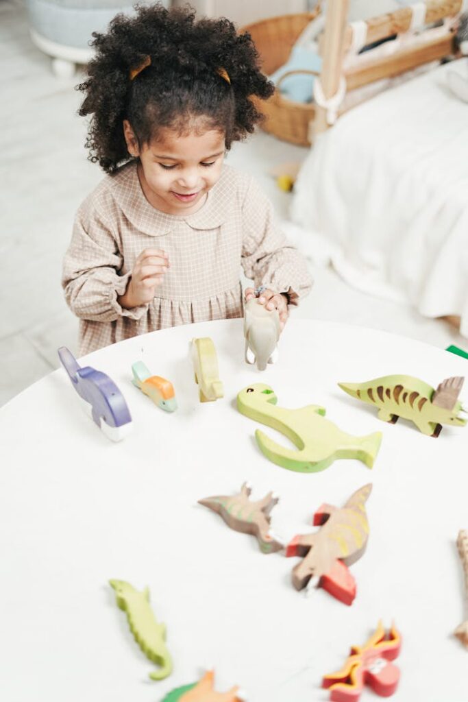 Cheerful child engages with colorful wooden dinosaur toys in a bright room.